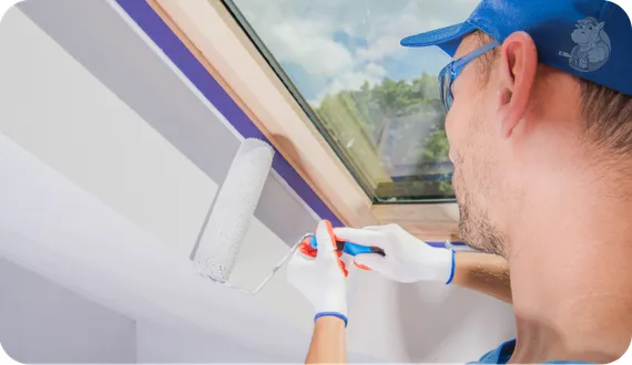 mężczyzna malujący krawędzie ścian